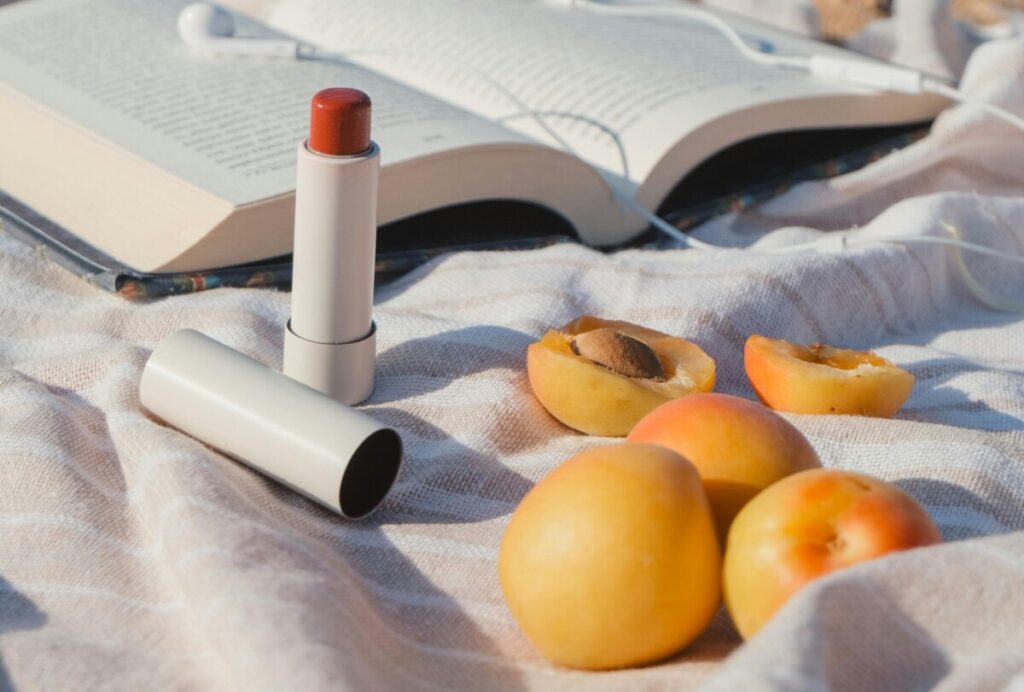 뚜껑이 열린 빨간색 립스틱과 살구는 딜도와 여성성기응 은유적으로 표현