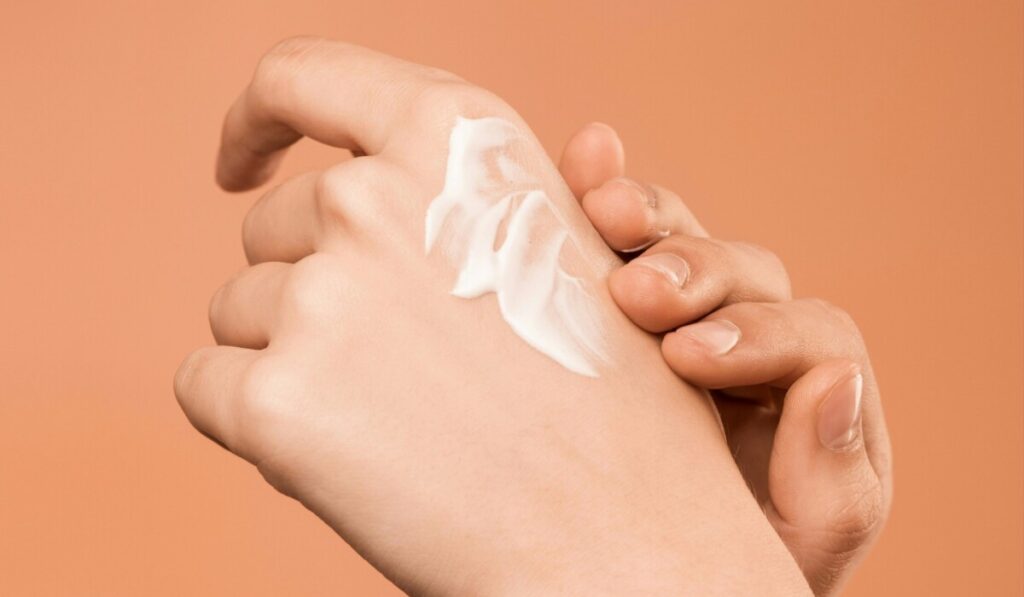 여자 손등에 크림을 바르는 모습