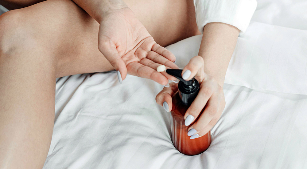 사람이 윤활제를 바르기 위해 손에 짜내고 있는 모습