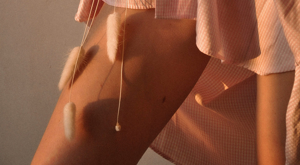 치마를 입은 여자로 보이는 허벅지가 보이고, 강아지풀을 닮은 개체가 에그형 바이브레이터를 연상시킨다