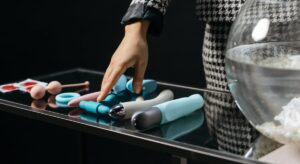 여러 딜도 중에 하나를 선택하기 위해 선을 뻗고 있는 여자