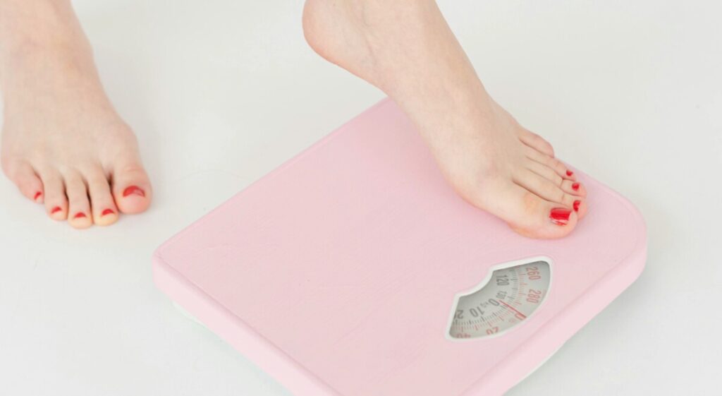 체중계 위에 올라선 발, 다이어트와 체중 관리