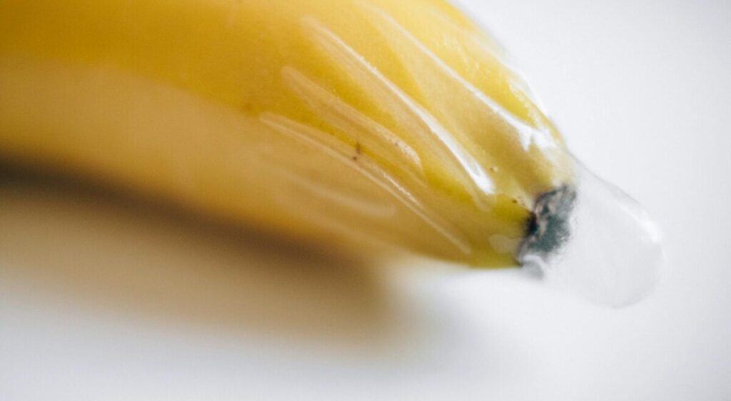 바나나 끝에 콘돔을 씌워 정액받이의 공기 제거 미흡으로 인한 콘돔 실수 가능성을 보여주는 이미지.