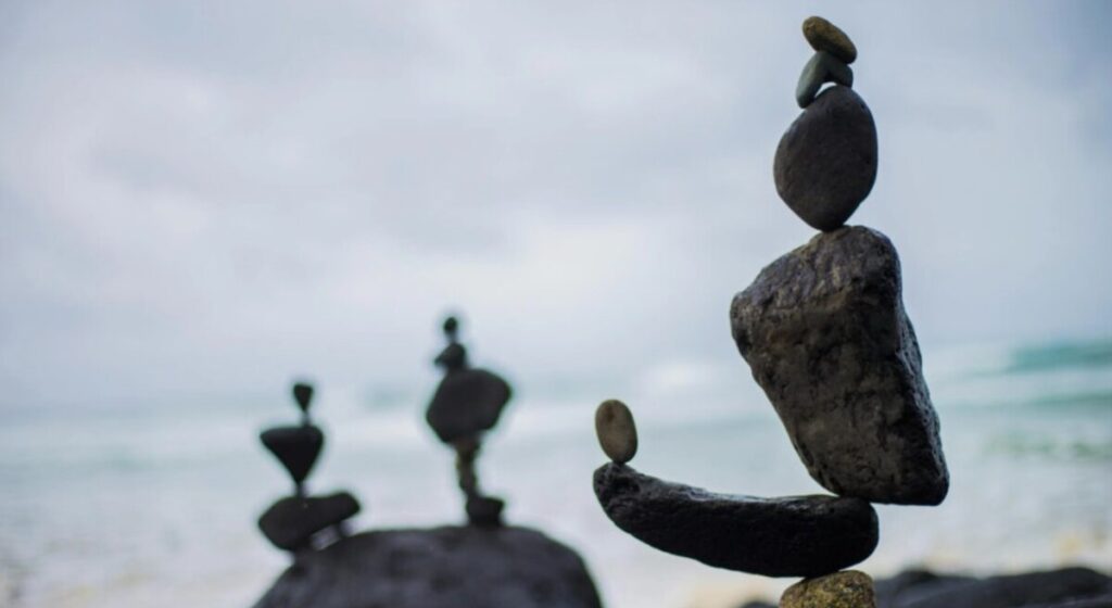 해변가에서 아슬아슬하게 균형을 유지하고 있는 돌탑과 성욕의 심신 균형